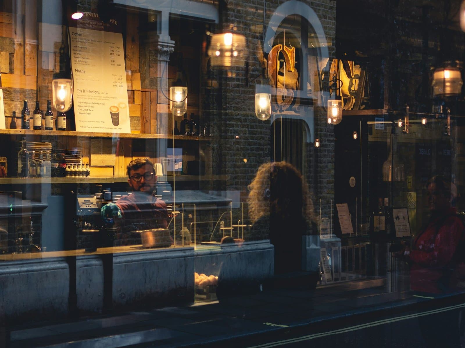 A dimly lit restaurant seen through a window at night